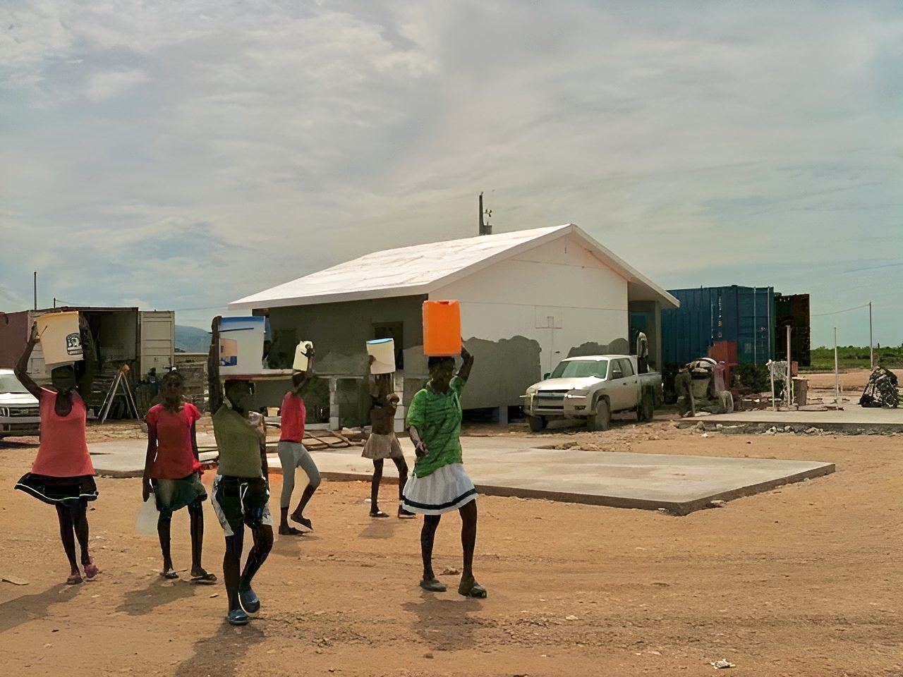 A completed SABS building in Haiti with residents walking past