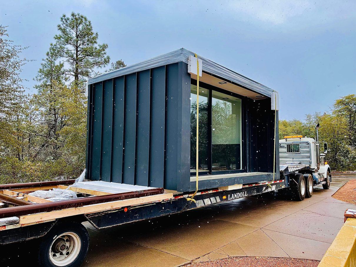 A finished SABS prefabricated building on a low-boy trailer